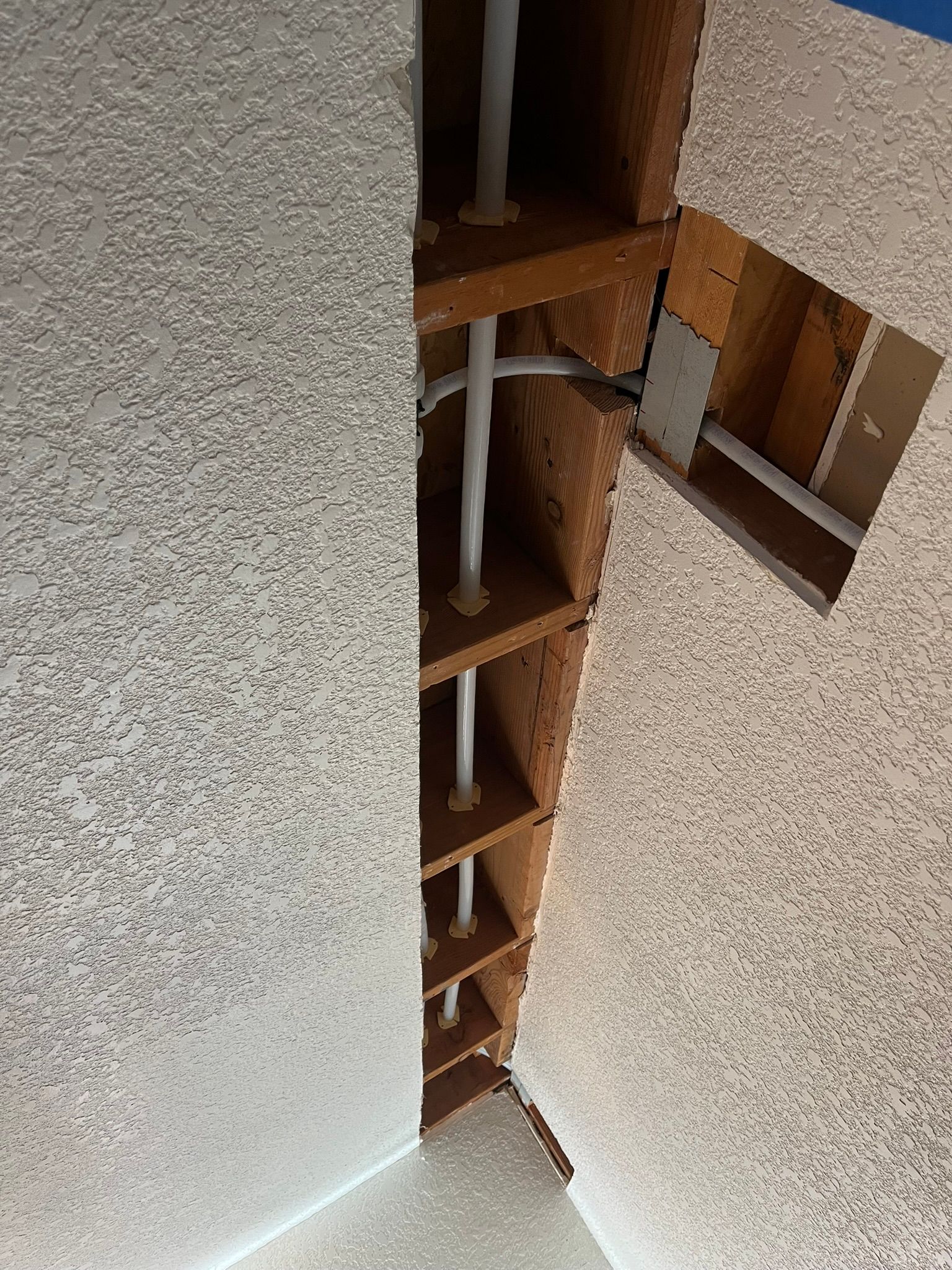 A ceiling with a hole in it and pipes coming out of it.