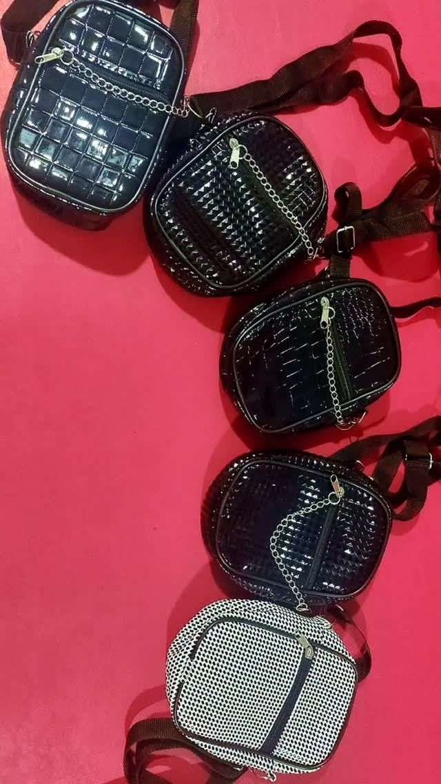 Cinco bolsos pequeños, brillantes y cruzados con diferentes estampados sobre un fondo rosa.