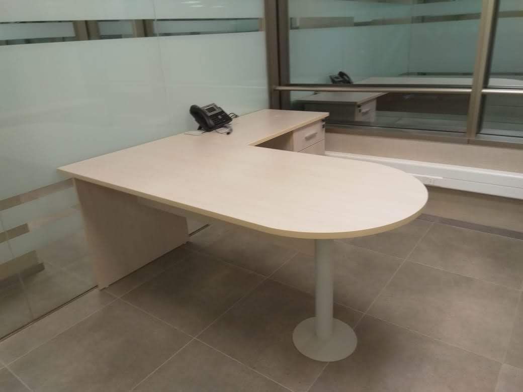 Una pequeña oficina con un escritorio y un teléfono.