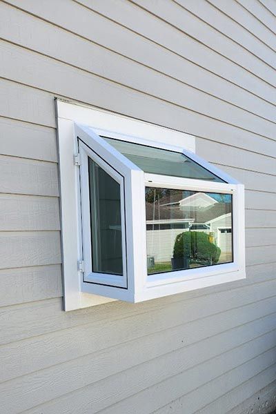 White casement window, partially open, mounted on white siding.