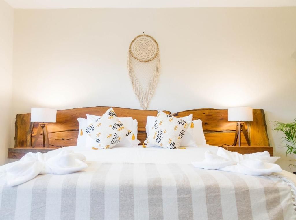 Hay un atrapasueños colgado de la pared encima de la cama. Hotel Maculan