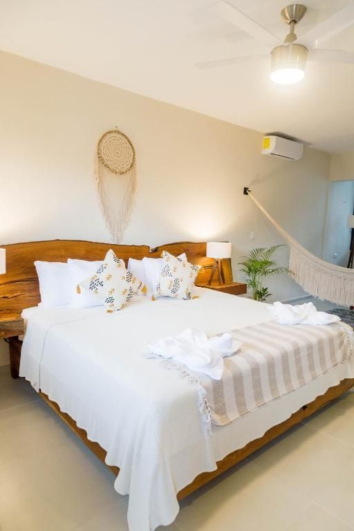 Un dormitorio con una cama king size y una hamaca. Hotel Maculan