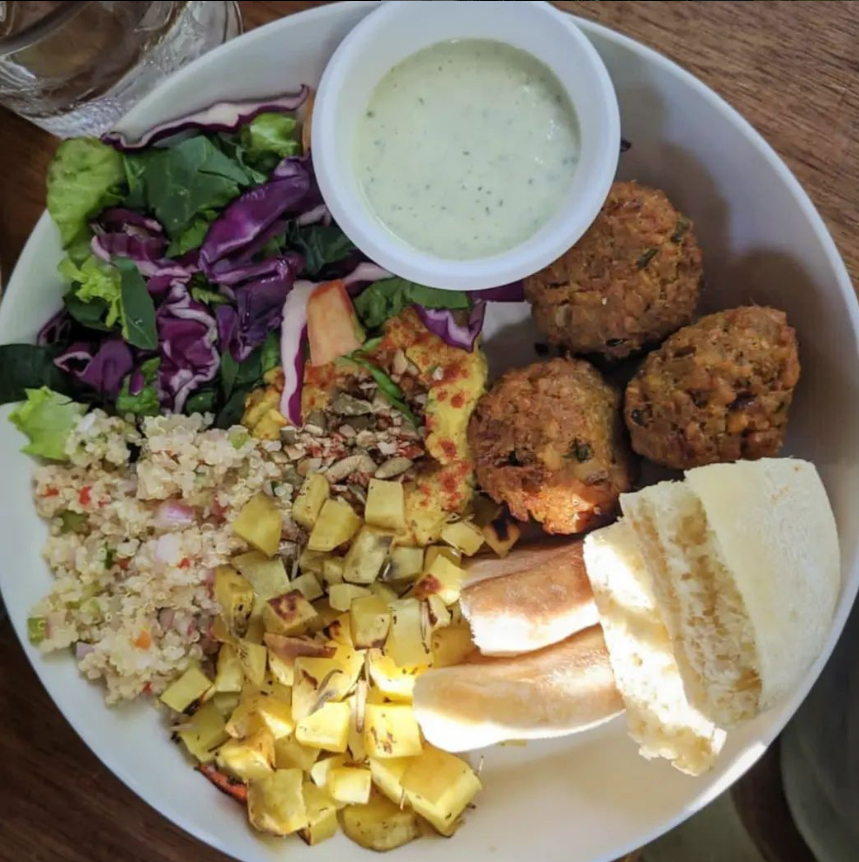 Un plato de comida con un tazón de aderezo ranchero encima.
