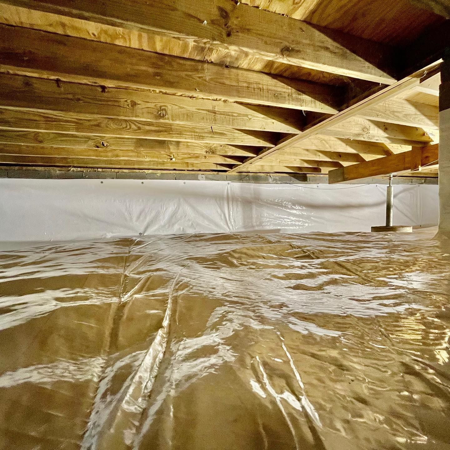 A basement with a clear plastic sheet on the floor