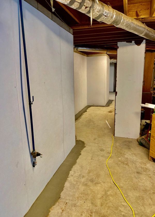 A basement with white walls and a yellow cord