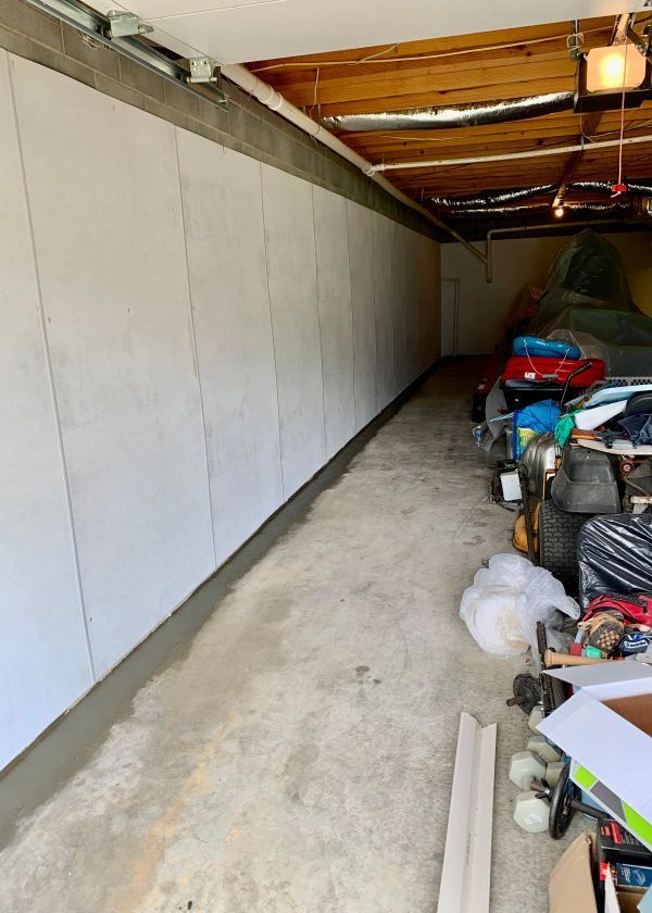 A long hallway in a garage with a bunch of tools on the floor.