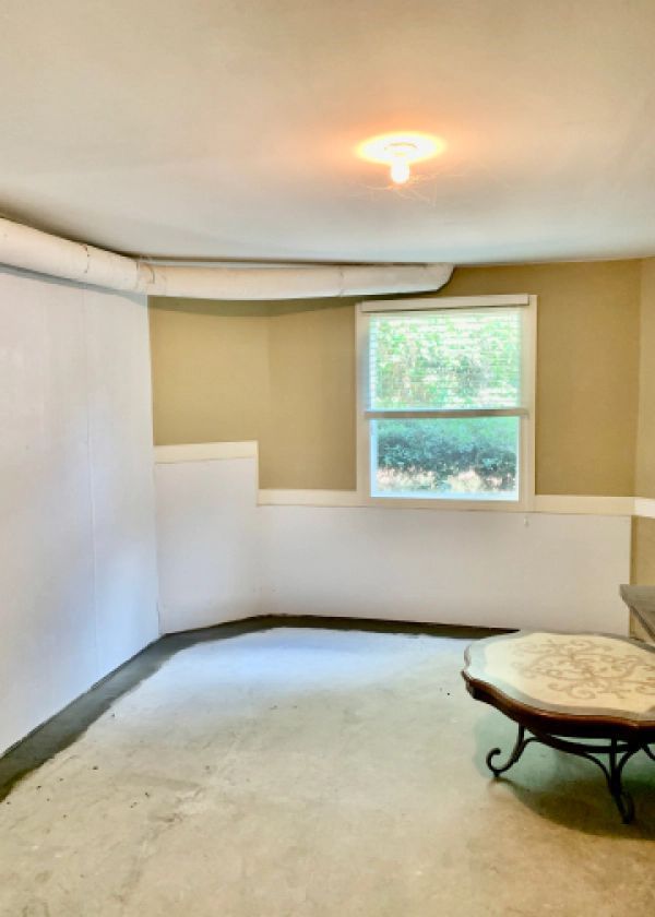 A living room with a couch , table , and window.