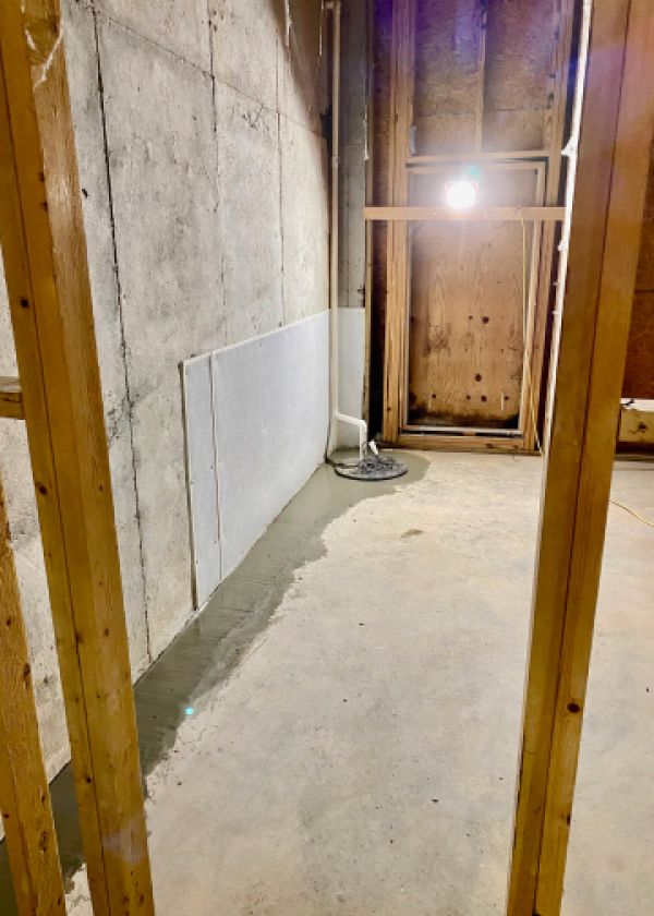 A room with a concrete wall and a wooden frame.