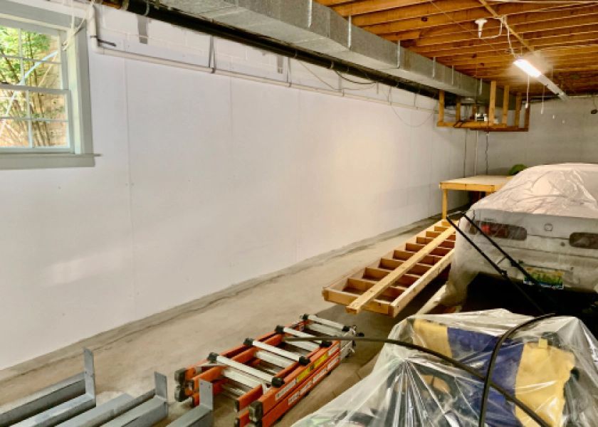 A garage with a ladder and a car in it.