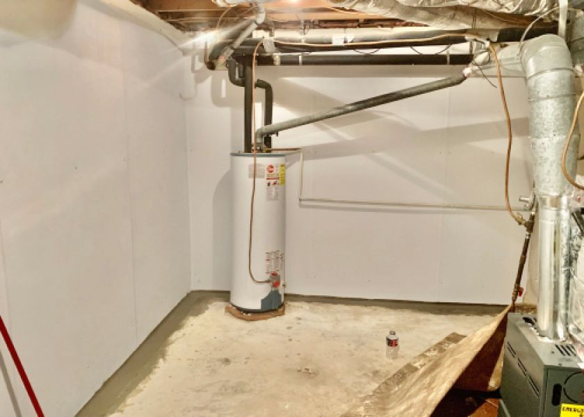 A basement with a water heater and a furnace.