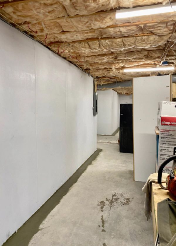A long hallway in a basement with white walls