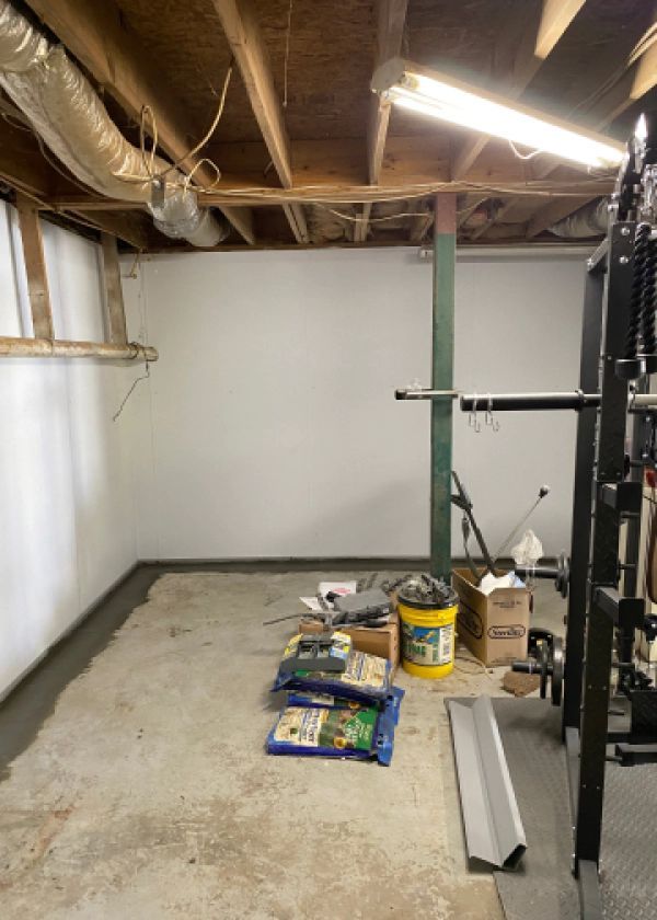 A basement with a lot of bags of dirt on the floor.