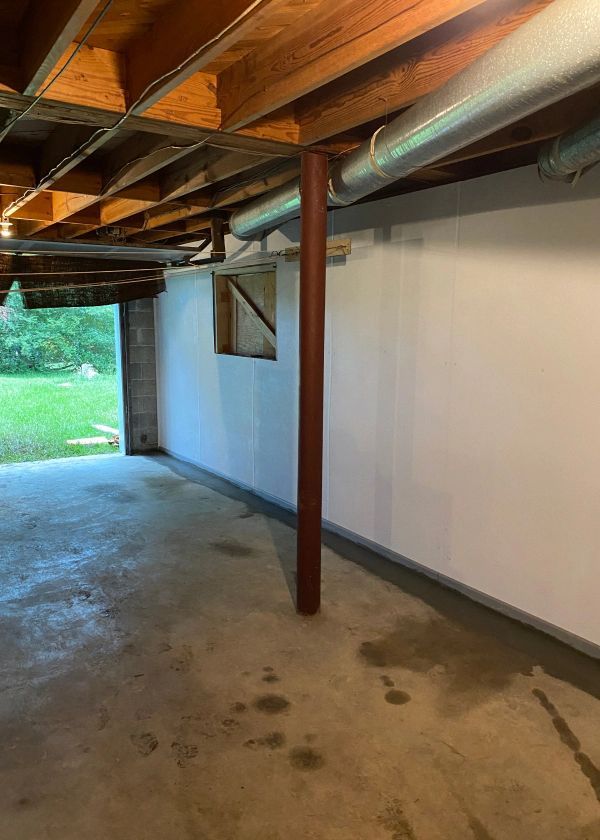 A basement with a wooden ceiling and a concrete floor.