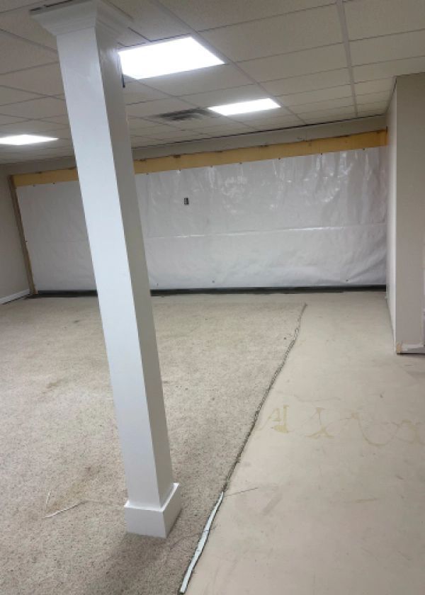 There is a white pole in the middle of the room.