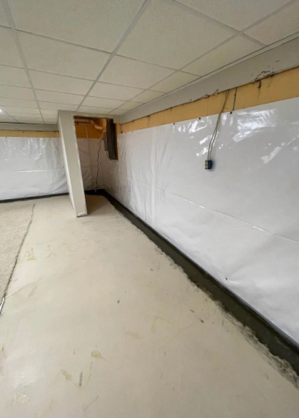 A basement with a white wall and a white floor.
