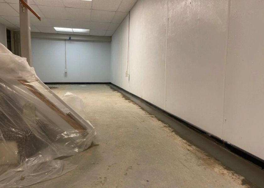 An empty room with a plastic bag on the floor and a white wall.