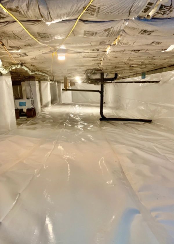 A basement with a lot of plastic on the floor and ceiling.