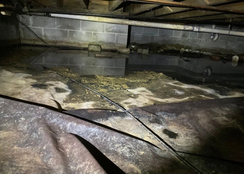A flooded basement with a lot of water coming out of it.