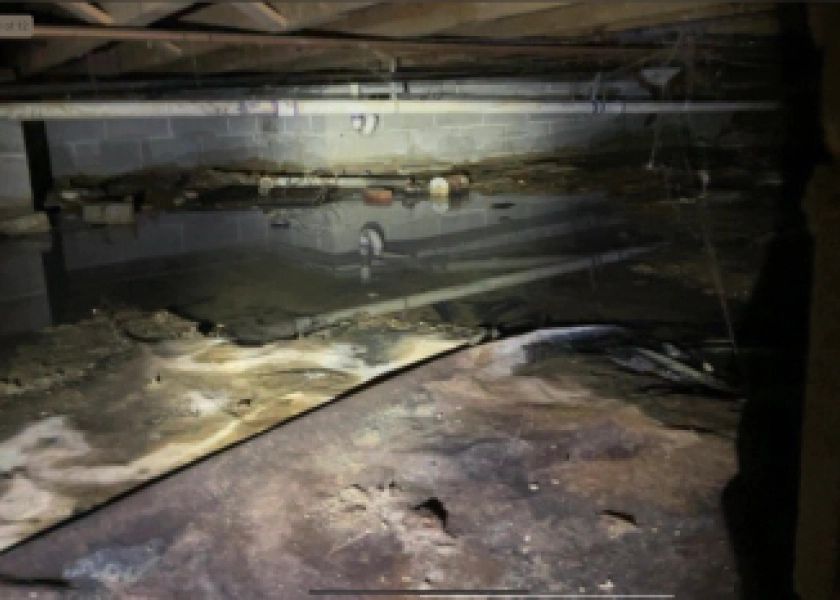 A flooded basement with a lot of water coming out of it.