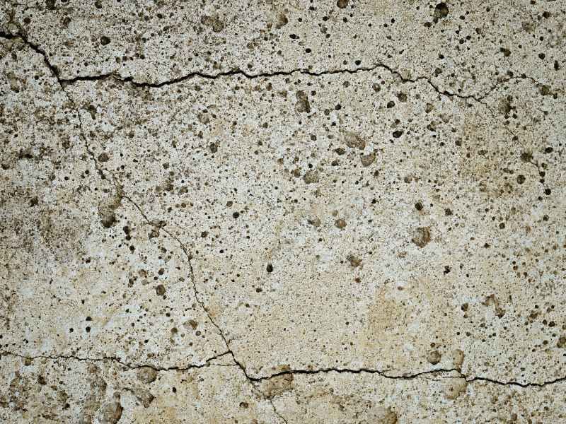 A close up of a cracked concrete wall.
