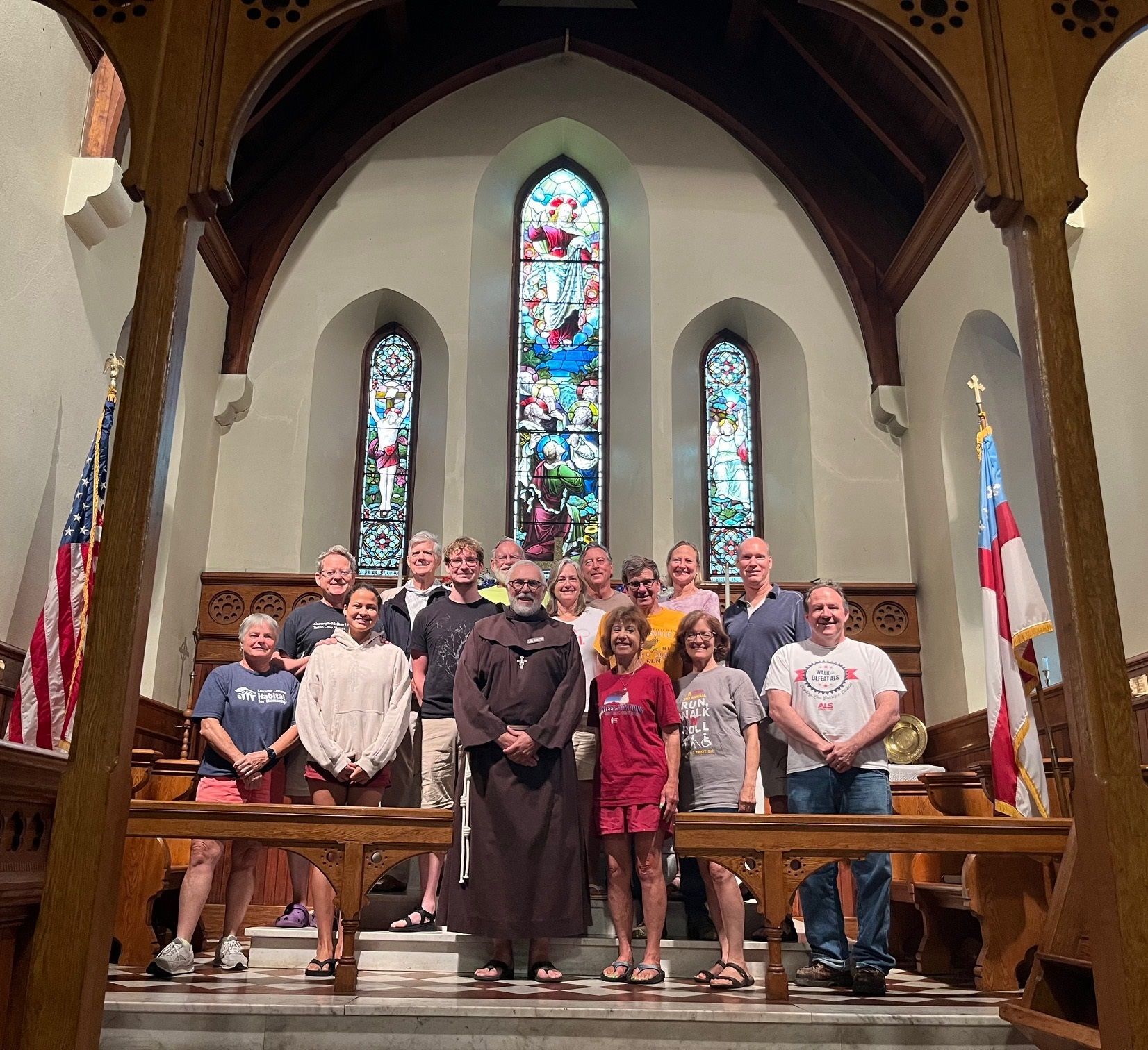 A group of people standing in front of a stained glass window in a church
