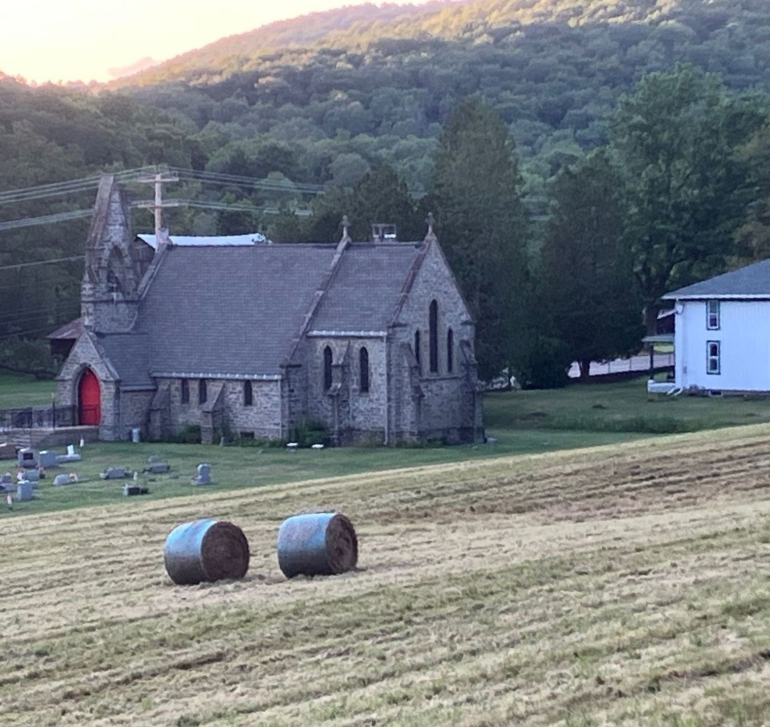 A church with bales of hay in front of it