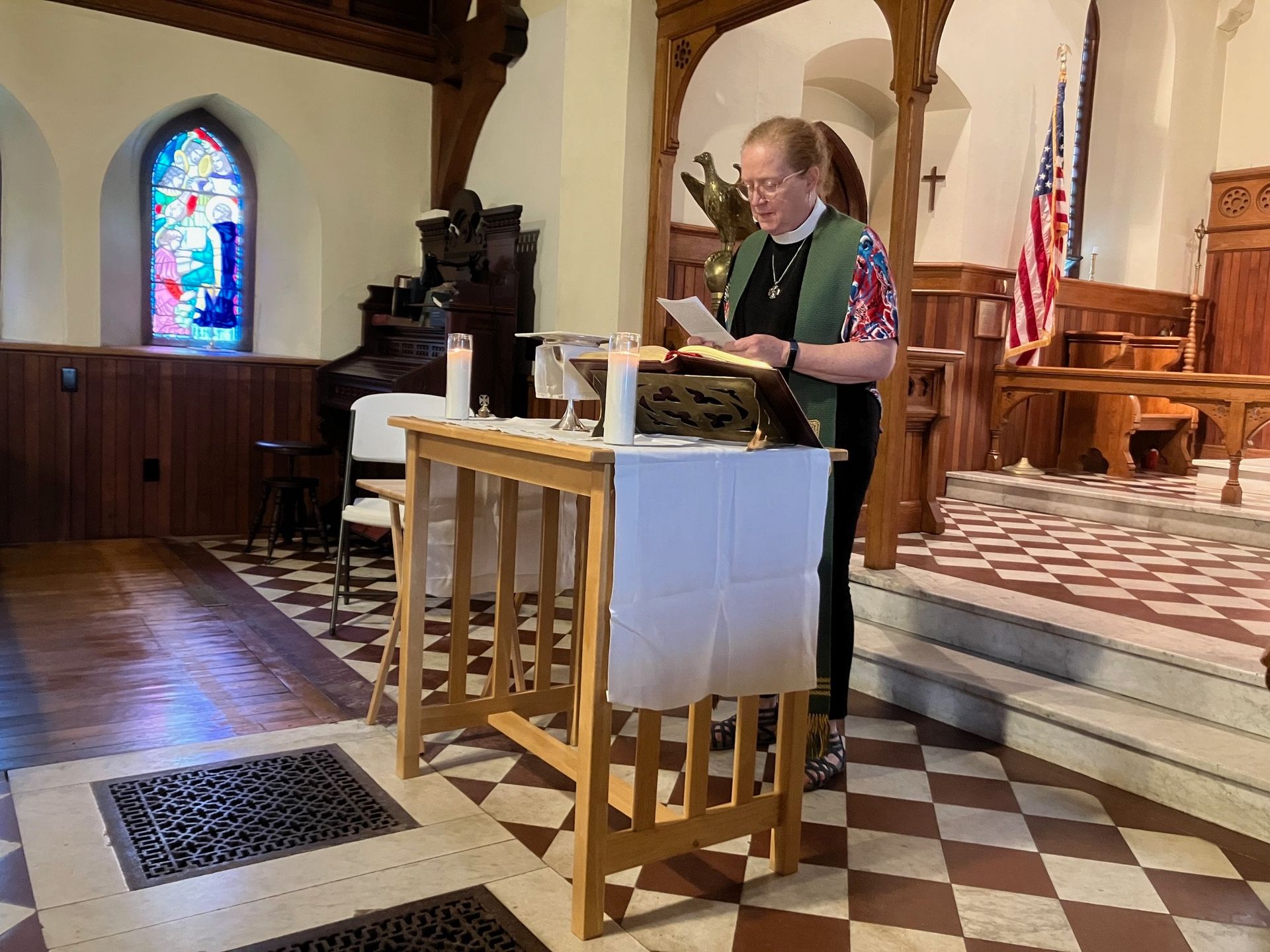 A woman is reading from a book in a church