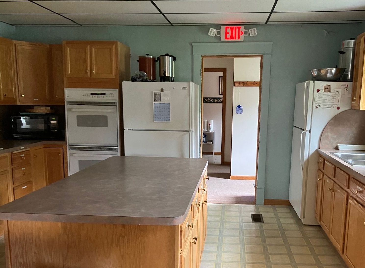 A kitchen with an exit sign above the door