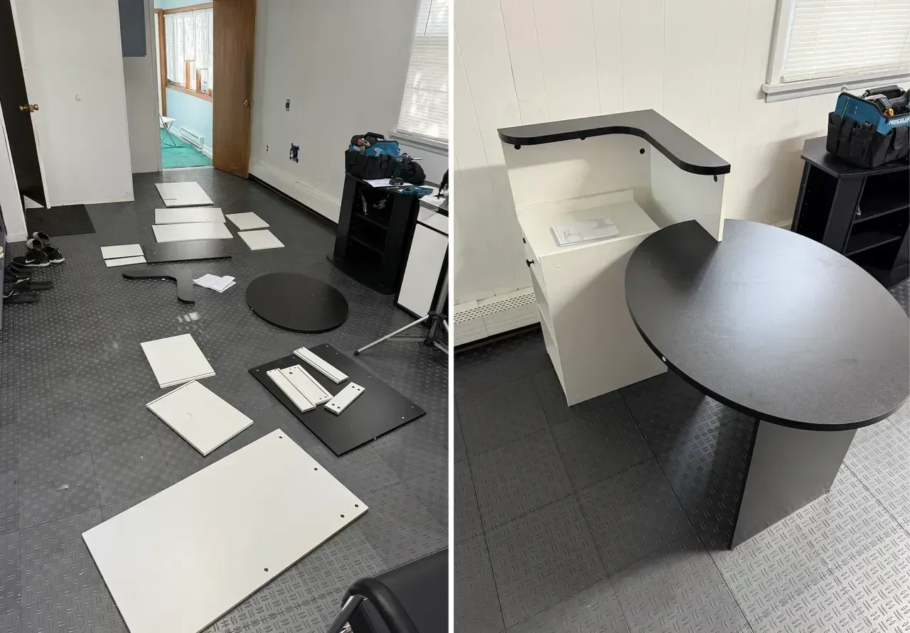 Damaged office cubicle area with papers scattered on the floor and a broken desk surface