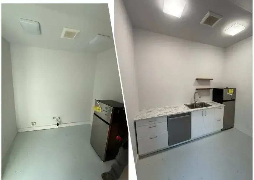 Empty laundry room with white cabinets, sink, and gray floor under ceiling lights