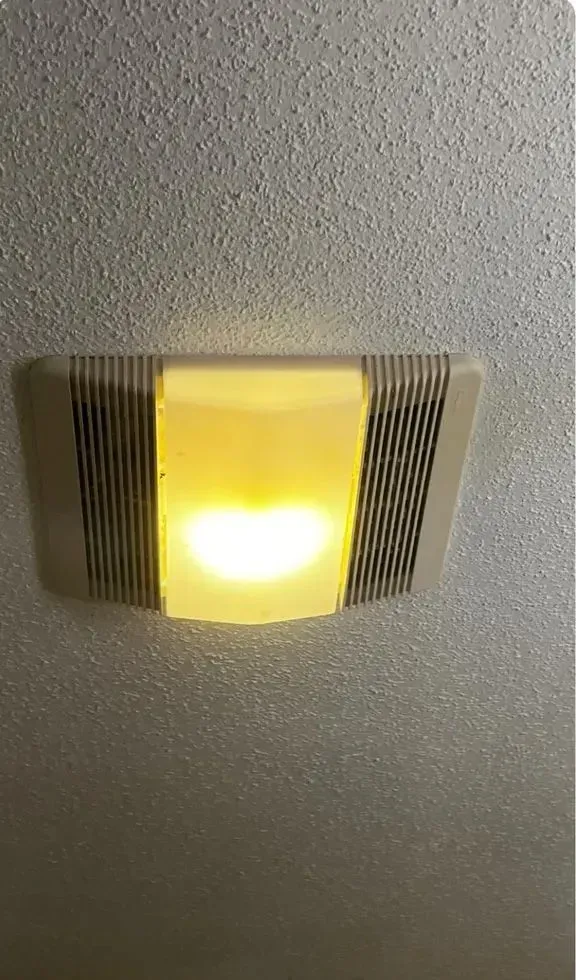 Ceiling-mounted light fixture with a yellow glowing center and gray vented sides