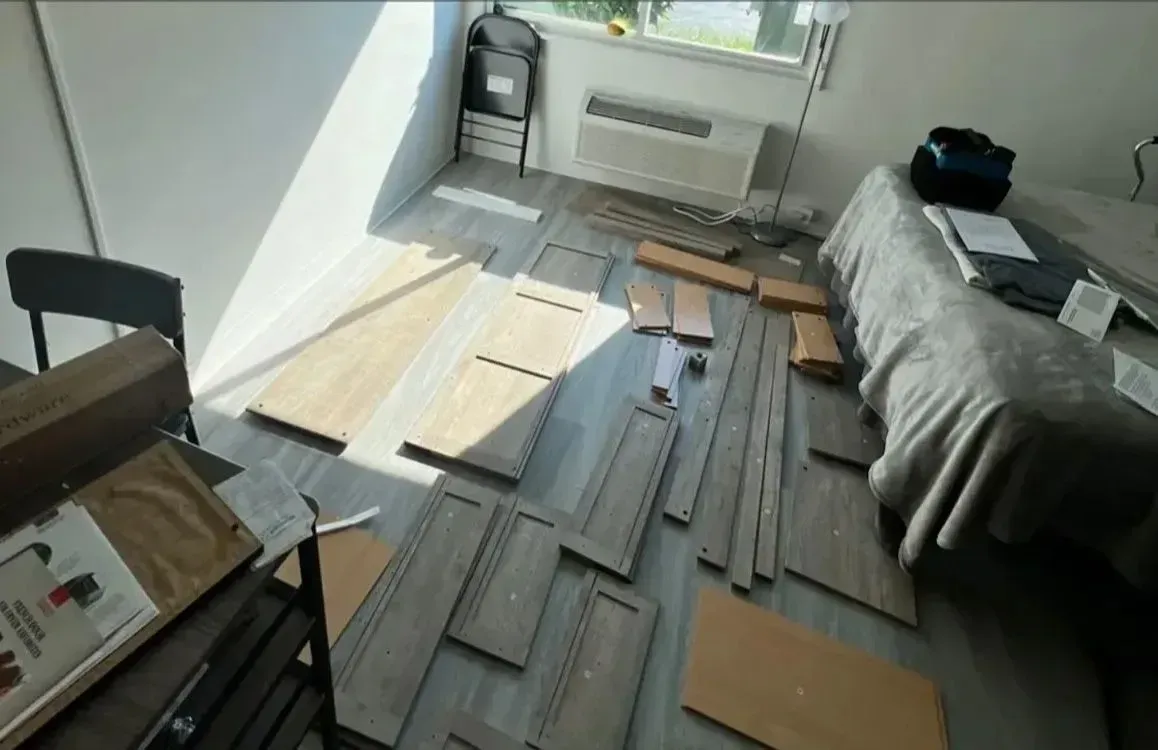 Messy living room with laminate flooring pieces spread across the floor during installation