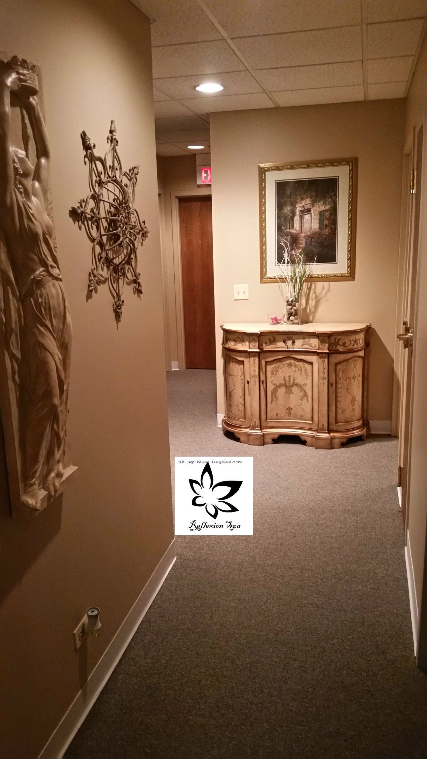 A hallway with a dresser and a picture on the wall