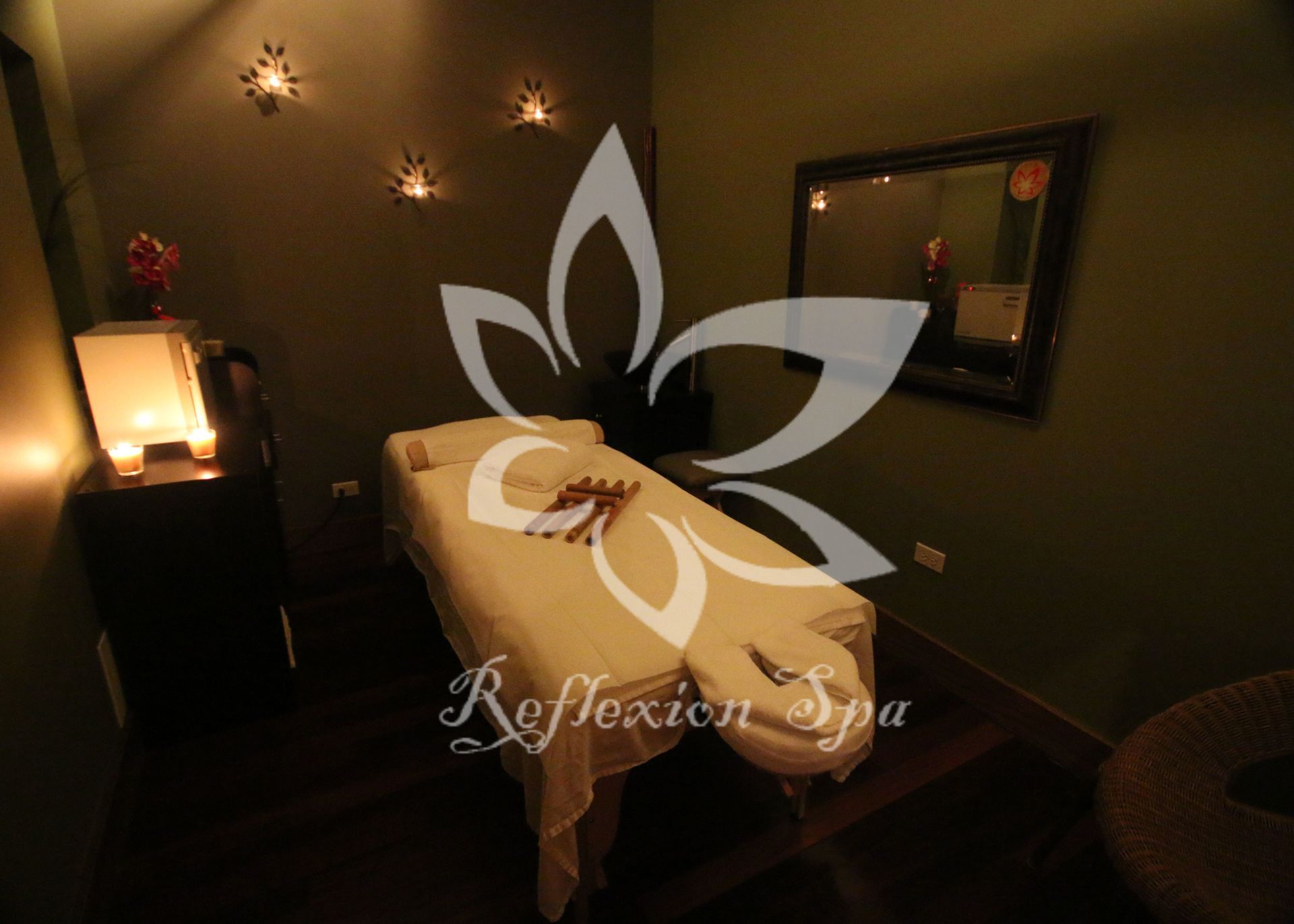 A massage table in a room that says reflexion spa