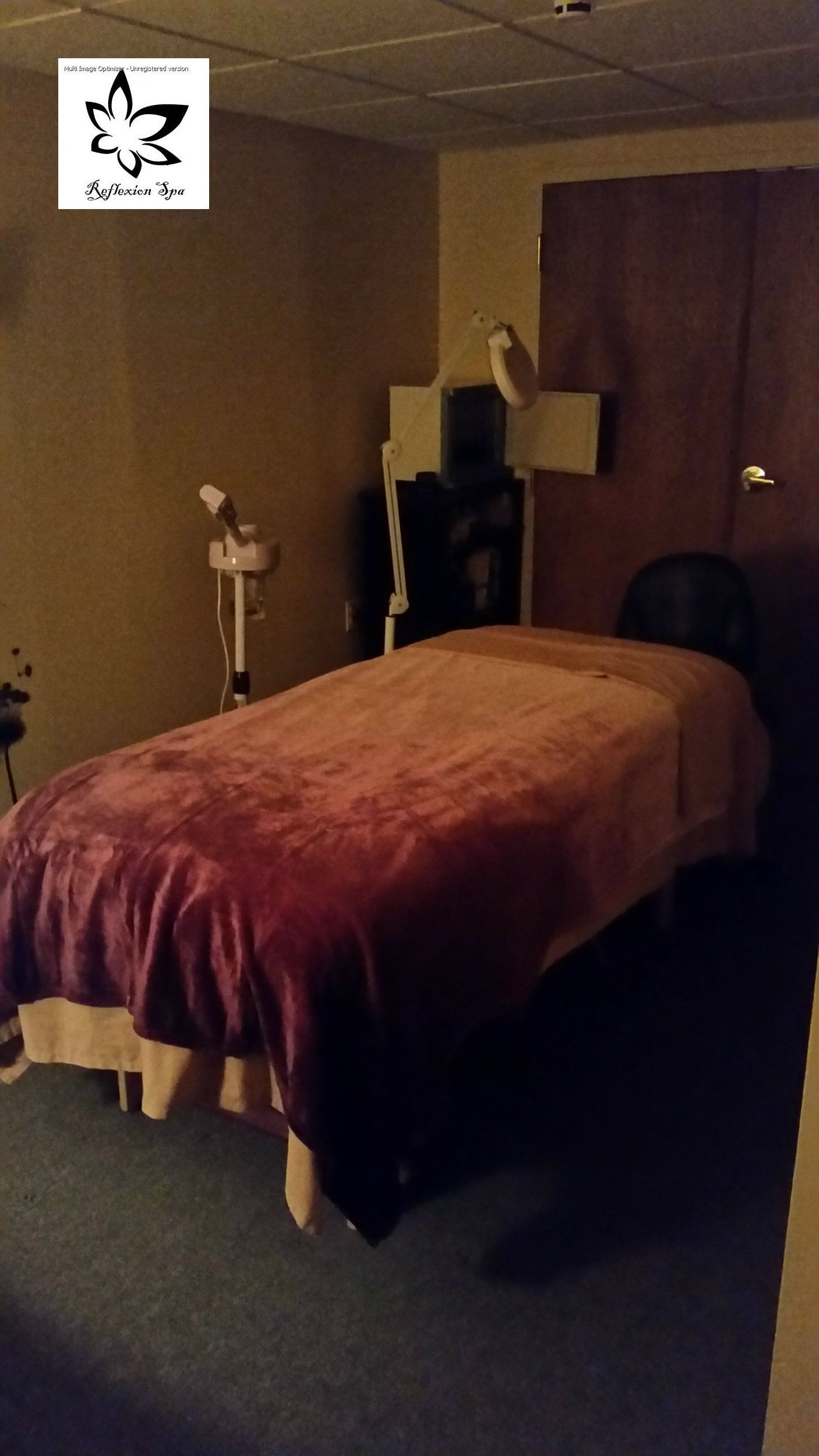 A massage table with a red blanket on it
