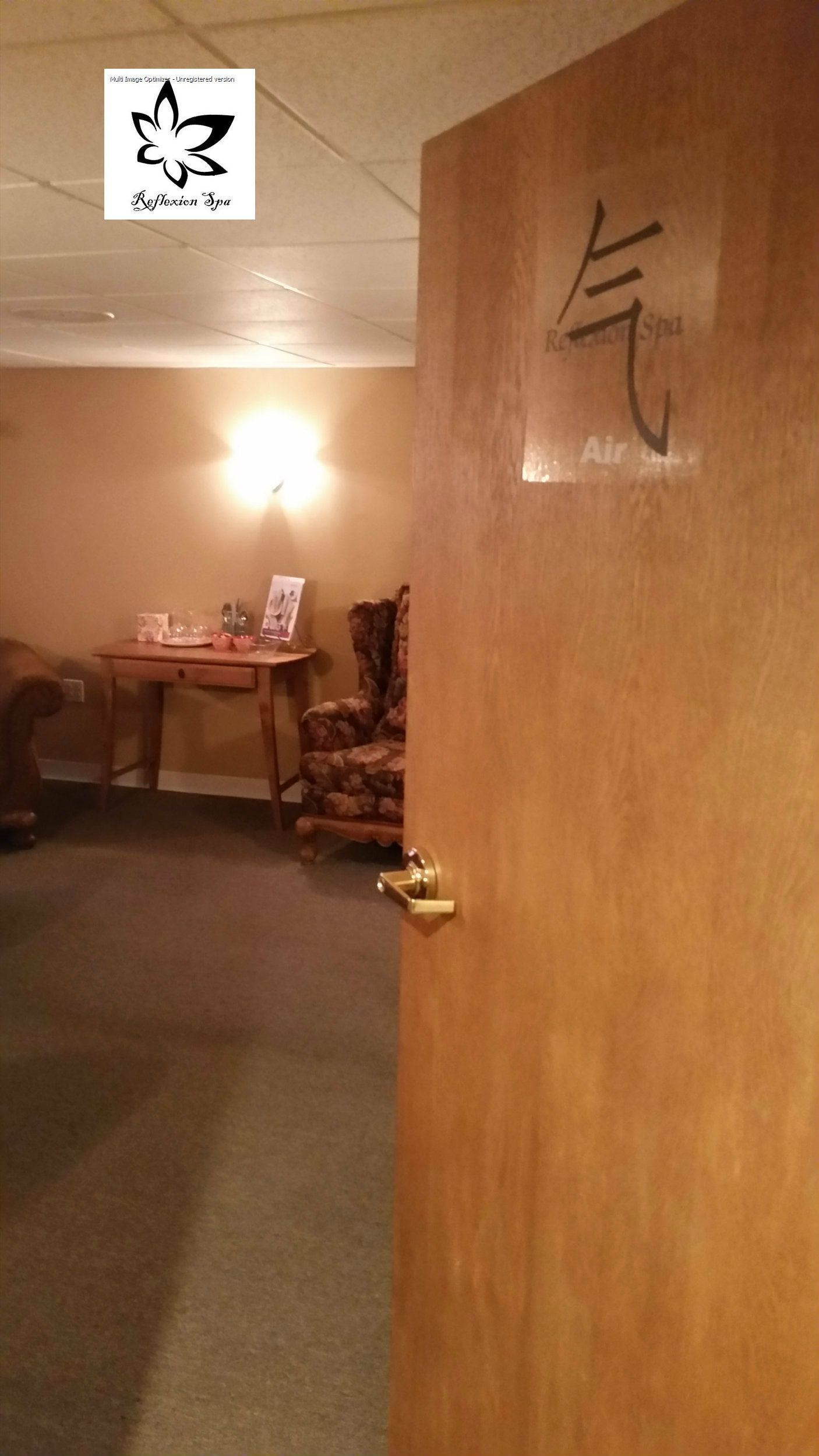 A room with a wooden door and a sign on the wall.