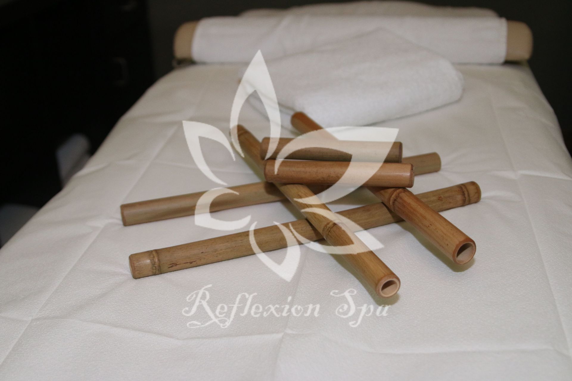 A bunch of bamboo sticks are laying on a massage table