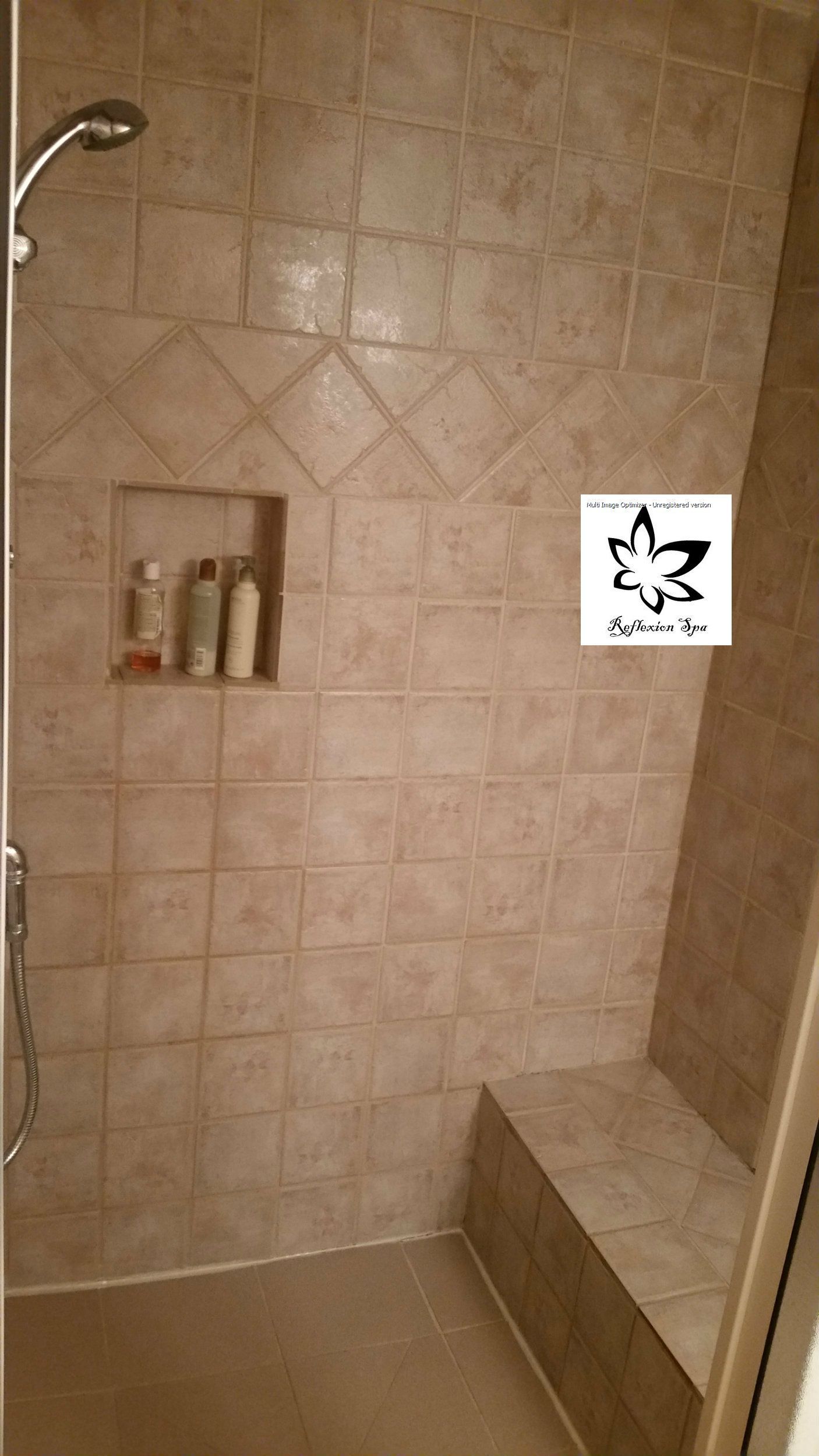 A bathroom with a walk in shower and a bench.