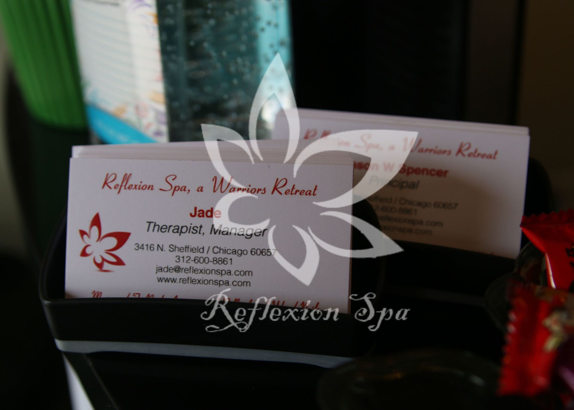 A business card for reflexion spa sits on a table