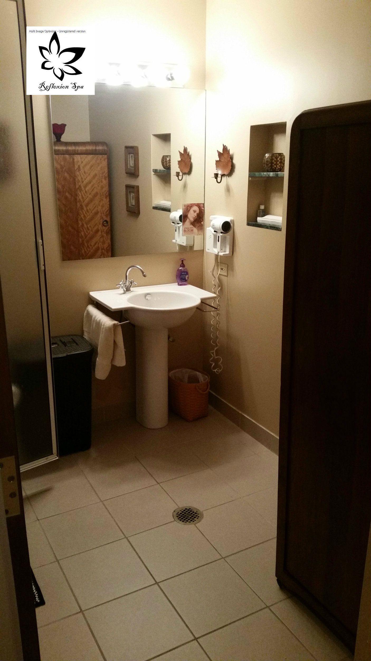 A bathroom with a pedestal sink and a mirror