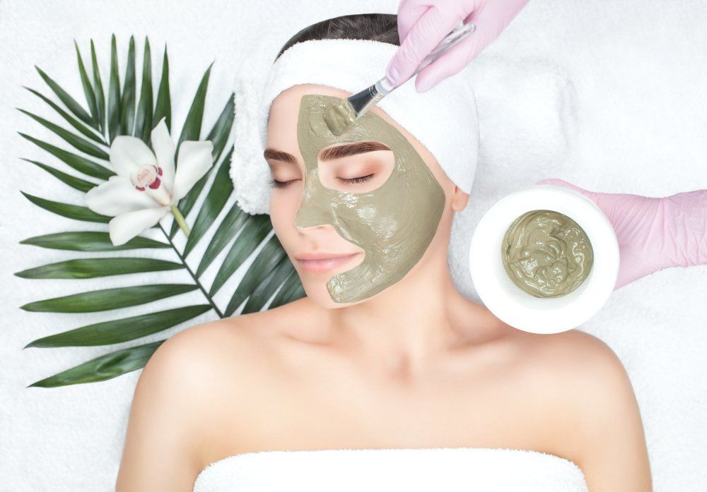 A woman is getting a facial mask at a spa.
