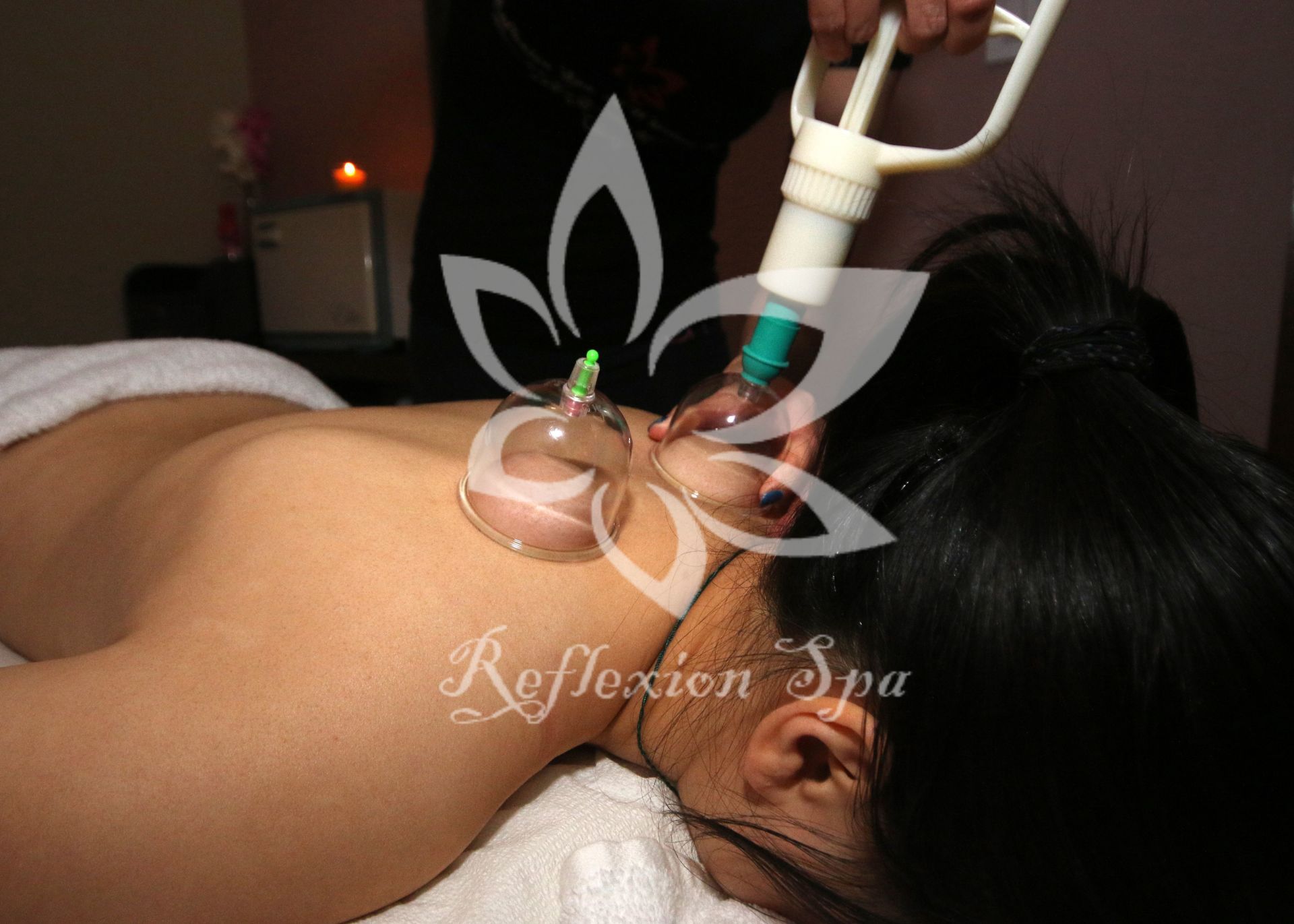 A woman is getting a cupping treatment at reflection spa