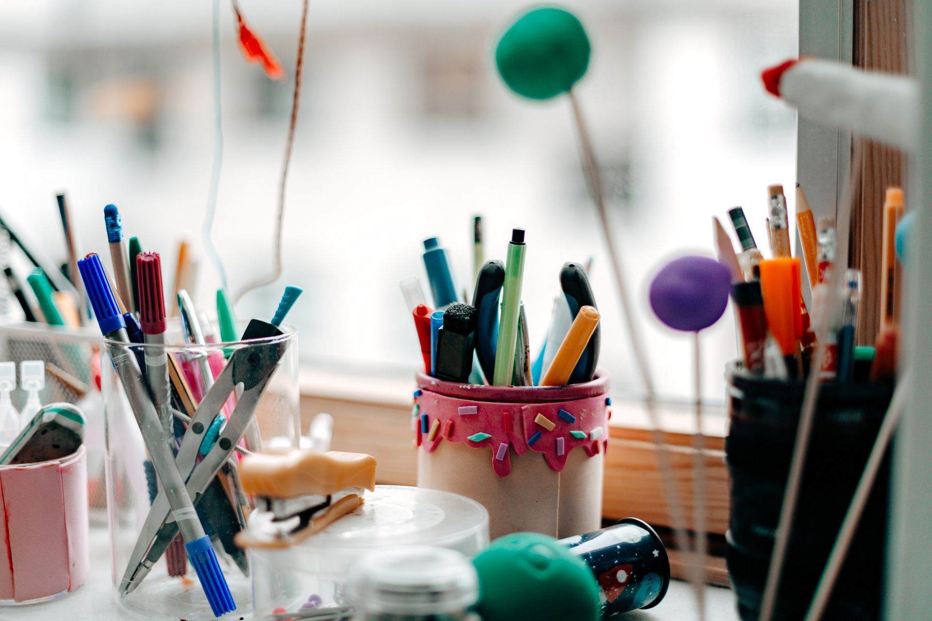 Penne e pennarelli sono in una tazza su un tavolo.