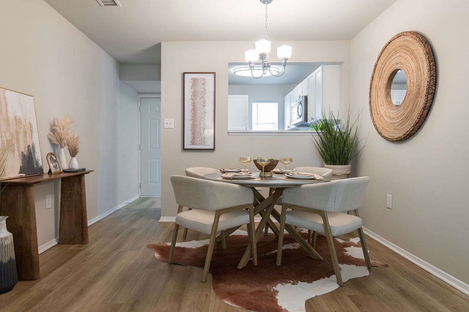 A dining room with a table and chairs and a cowhide rug.