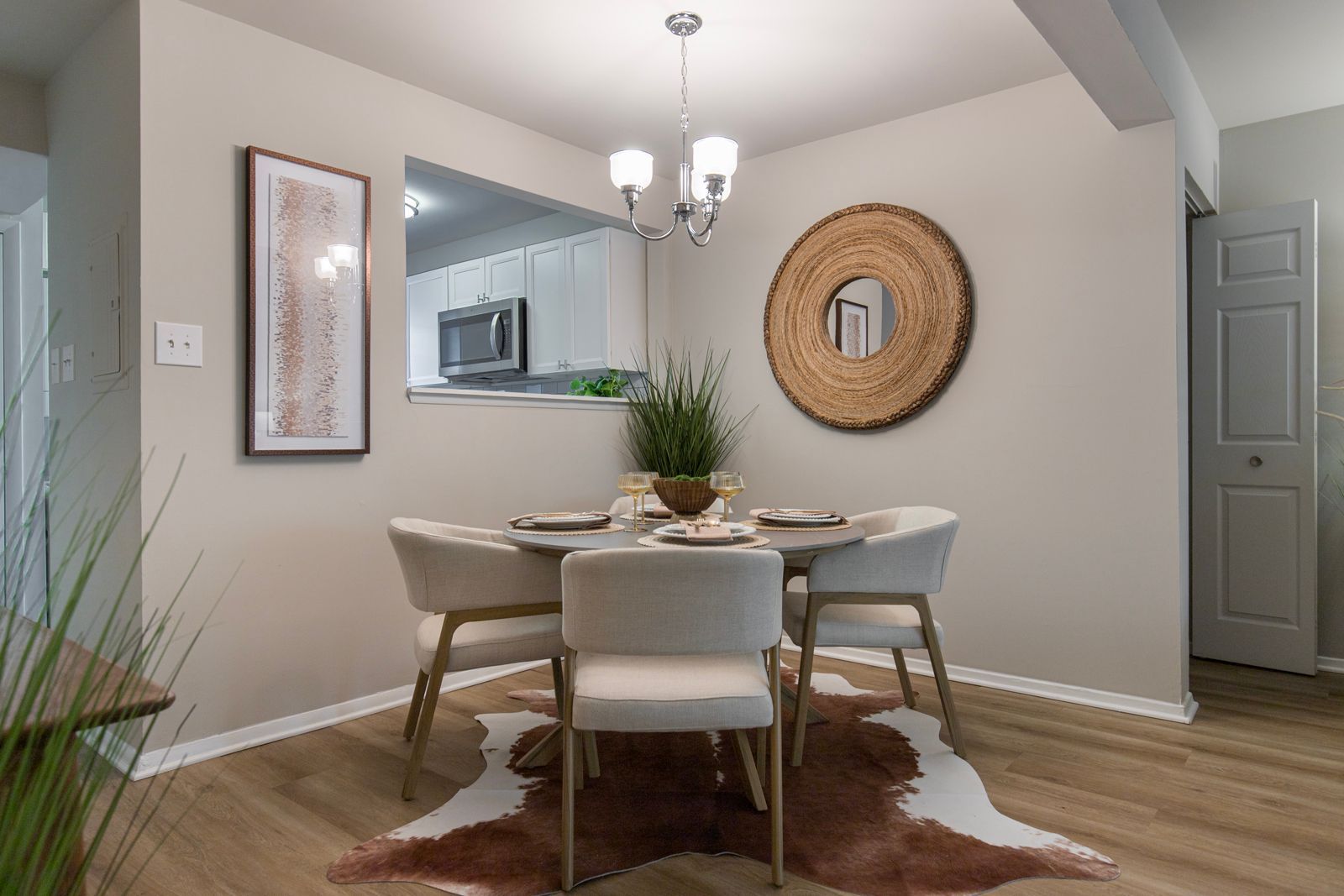 A dining room with a table and chairs and a cowhide rug.