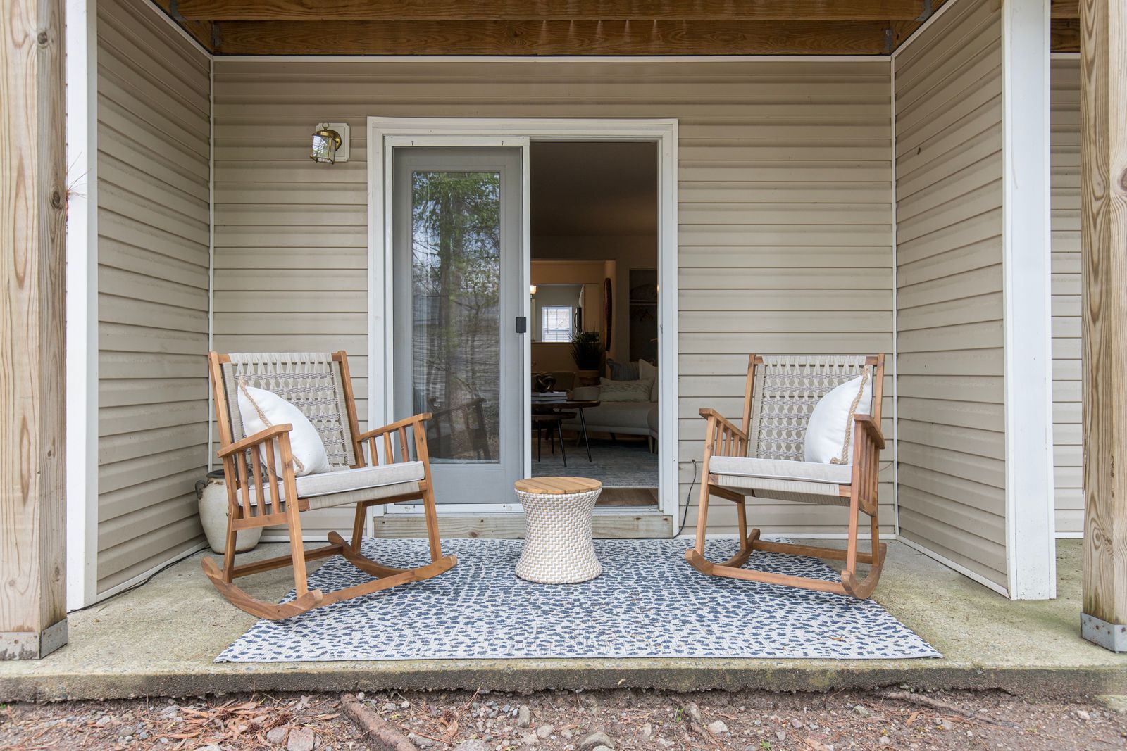 There are two rocking chairs on the porch of a house.