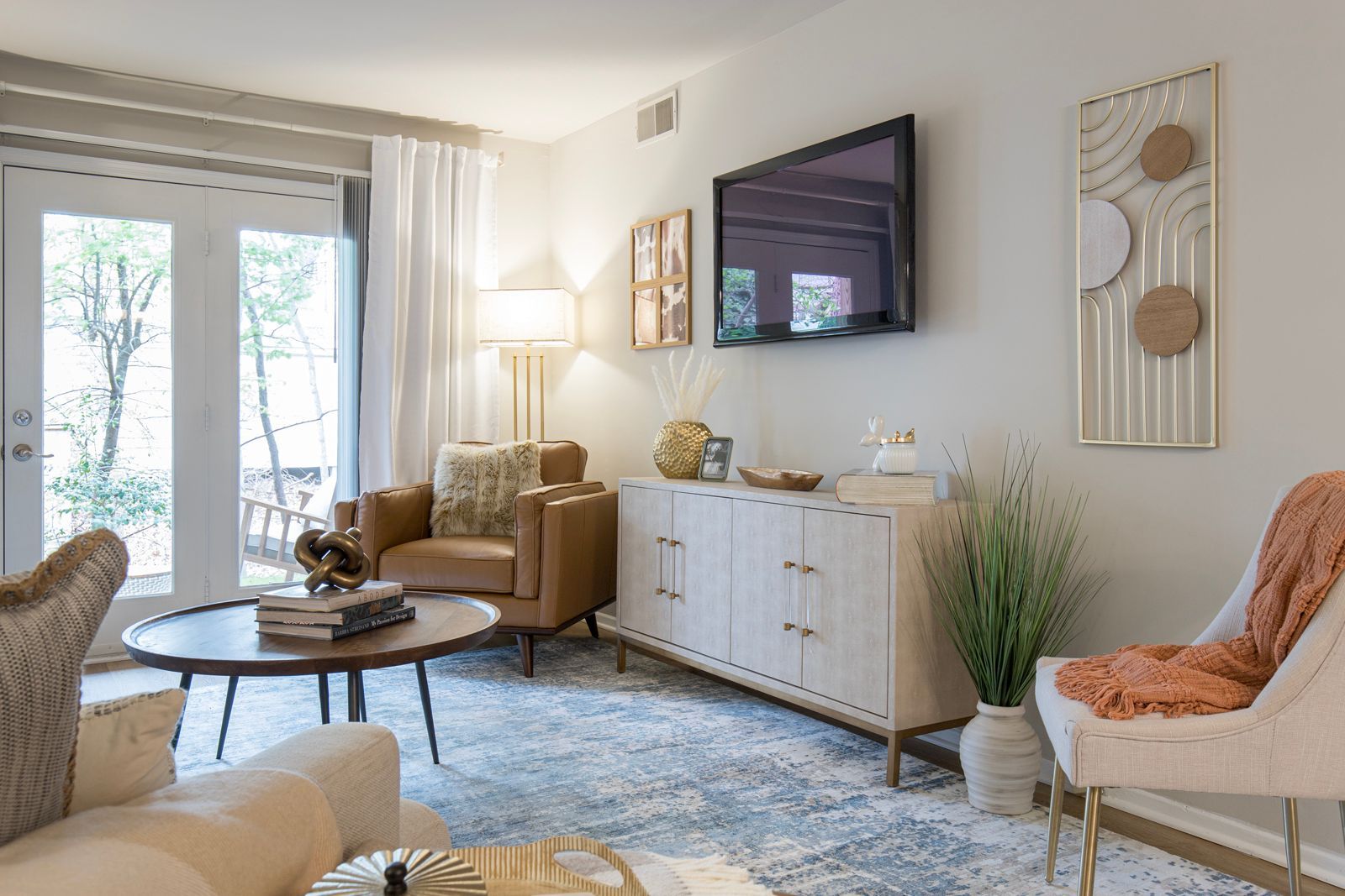 A living room with a couch, chair, table and television.