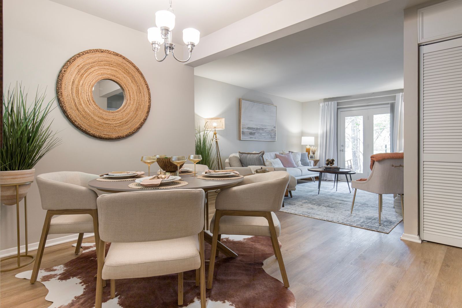 A dining room with a table and chairs and a cowhide rug.