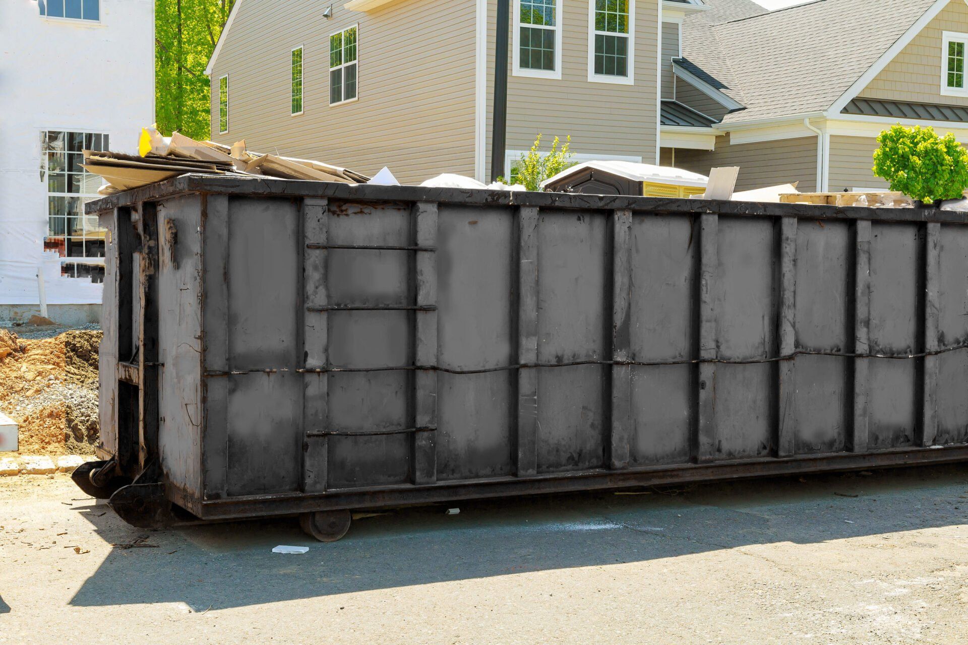 black dumpster rental in front of home in Lafayette LA