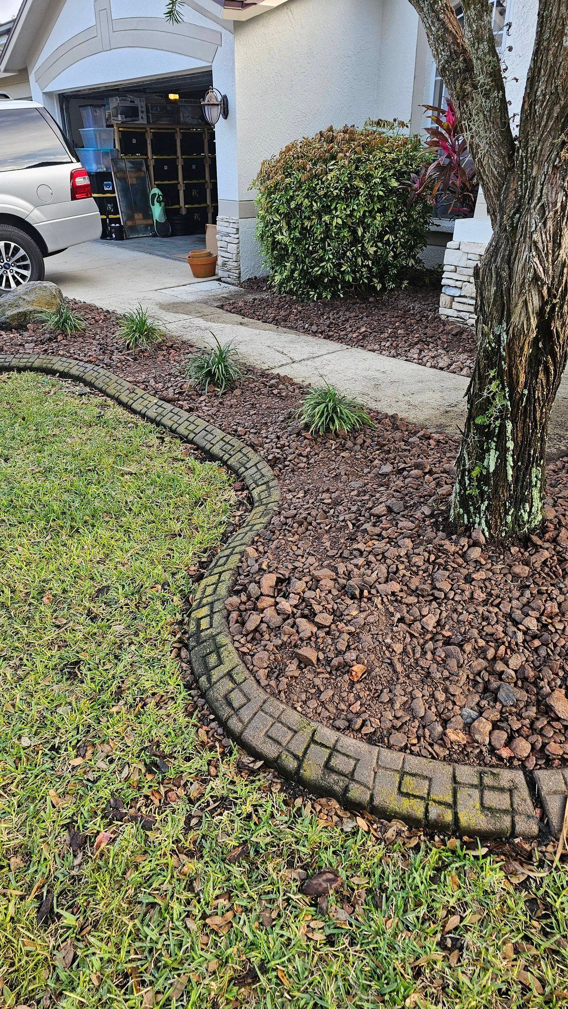 Residential landscaping with rock bed, shrubs, and trimmed bushes near home entrance in Plant City, FL